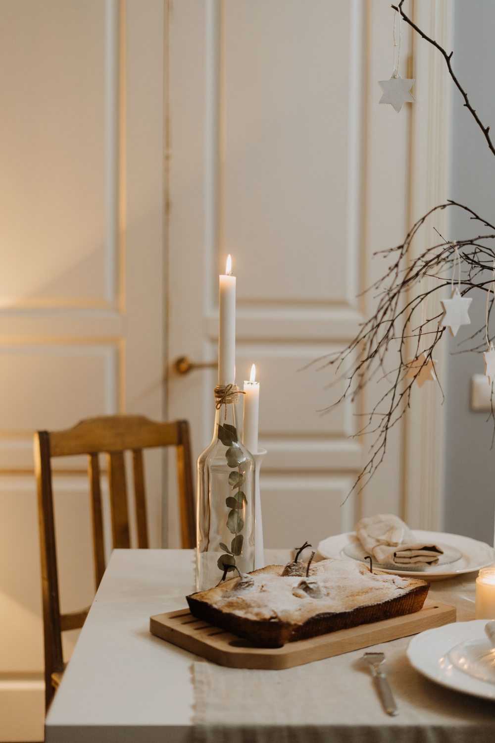 Real holiday dining scene with candlelight, a cake and a simple place setting